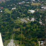 green park seen from the air, mainly trees but the iconic Palm House of Kew Gardens is recognizable